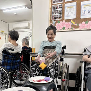 長輩們拿起彩色小球，瞄準目標